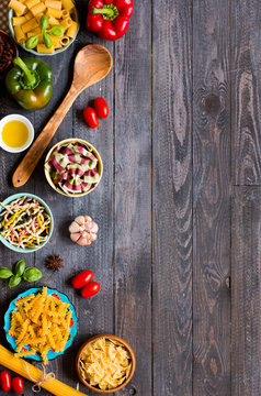 Different types of pasta with various types of vegetables, health or vegetarian concept on a wooden background,  Top view