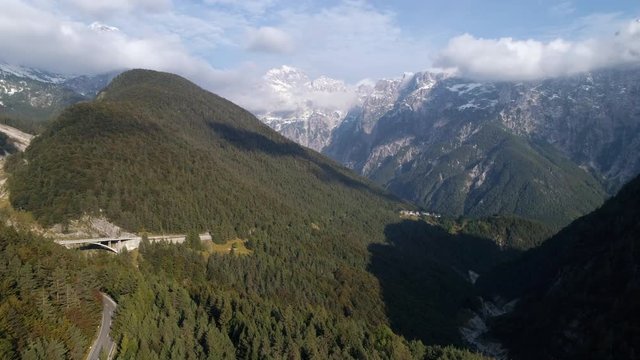 Aerial view high above the mountains and forest near Predil Pass Slovenia viewing the Julian Alps.