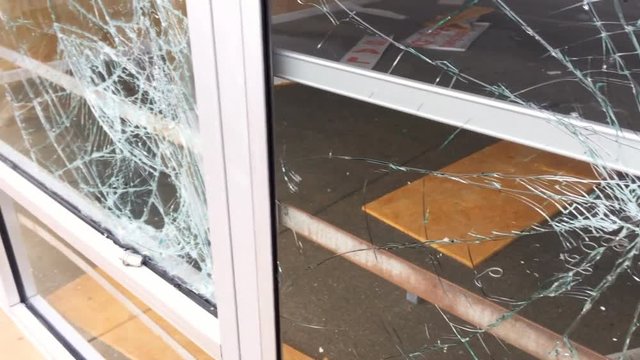 Broken  and shattered glass  from a riot or protest.