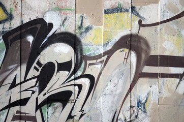 A fragment of detailed graffiti of a drawing made with aerosol paints on a wall of concrete tiles....