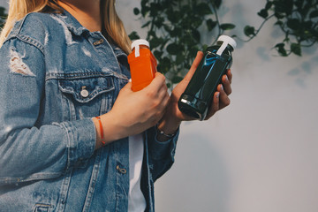 Woman holding plastic bottles with fresh detox pressed juice. Organic detox diet vegetable juice concept. Carrot and celery