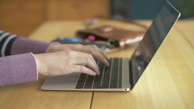 Dolly Shot Of Female Using Laptop At Wooden Table