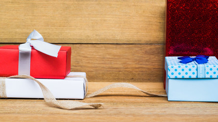 Red, blue, white gift box on wood table. Copy space. Christmas, new year, giving, birthday concept. Still life gift box on table concept. Gifts for important dates such as New Year's Day, Christmas.