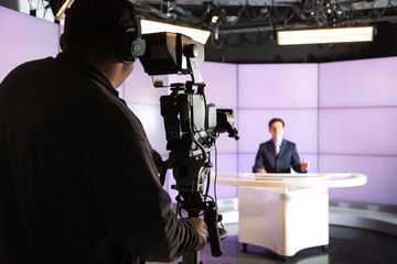 Closeup of a Camera Operator Filming an Anchorman