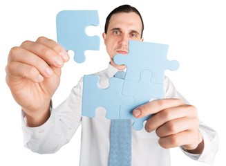 Businessman Combining Puzzle Pieces Together