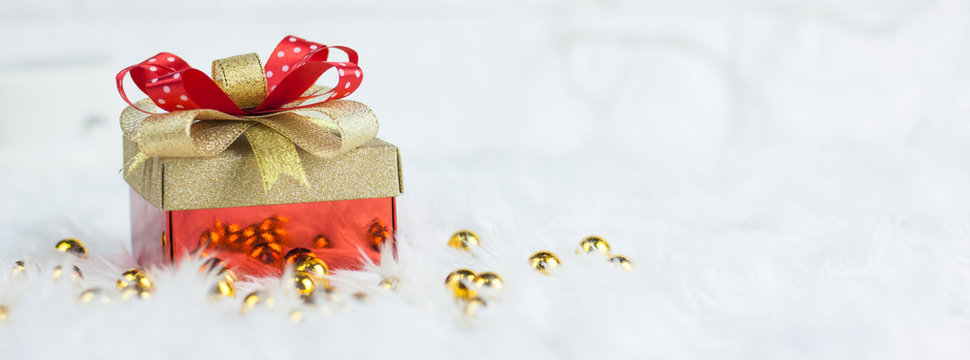 Merry christmas gold gift box with red ribbons on white mink cotton background.select focus and copy space for your text.Banner Christmas and valentine concept