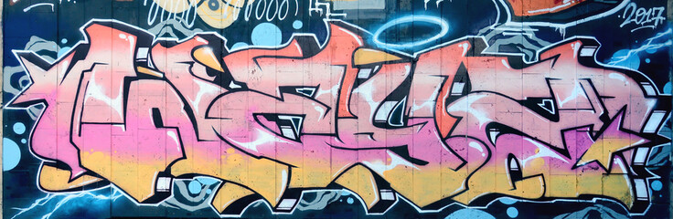 Ein Fragment eines detaillierten Graffitis einer Zeichnung, die mit Aerosolfarben auf einer Wand aus Betonfliesen erstellt wurde. Hintergrundbild der Straßenkunst in beigen und rosa Farbtönen © mehaniq41