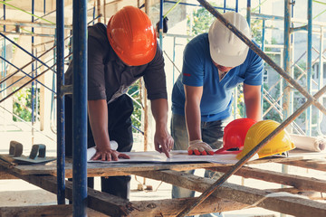 Construction concepts, Engineer and Architect working at Construction Site with blueprint, Vintage...