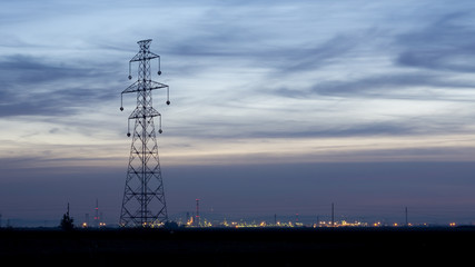 Fototapeta na wymiar big electricity tower with city in background