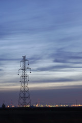 big electricity tower with city in background