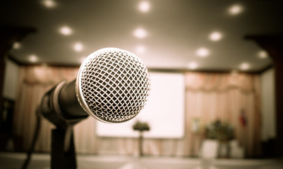 Microphone on abstract blurred of front podium and speech in seminar room or speaking conference...