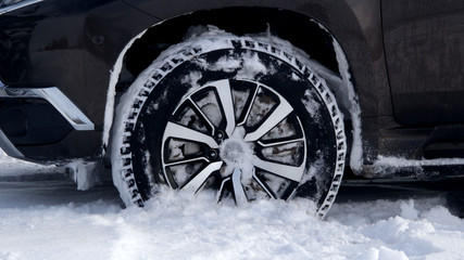 Fototapeta na wymiar Off road truck wheel packed with snow at winter stock photo 