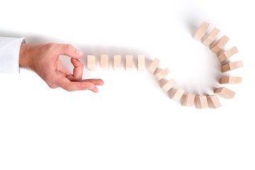 Hand Pushing a Question Mark Made with Domino Pieces