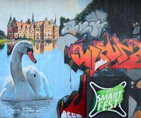 A fragment of detailed graffiti of a drawing made with aerosol paints on a wall of concrete tiles. Background image of street art with a huge white swan