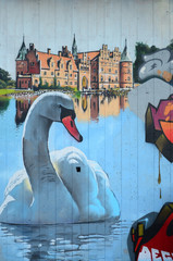A fragment of detailed graffiti of a drawing made with aerosol paints on a wall of concrete tiles. Background image of street art with a huge white swan