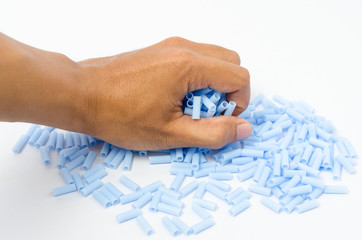 Blue plastic bead in human hand