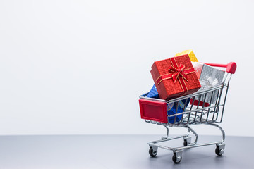 Shopping trolley with christmas gift on white background, copy space using for Christmas greeting card, New Year and happy birthday present decoration concept.