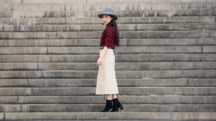 Beautiful Chinese woman stand with steps background, full length portrait.
