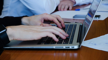 Young professional businessman wearing black turtleneck and using modern laptop, Close-up of male hands typing on notebook compute