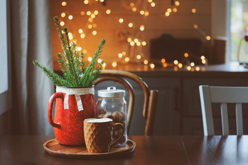 Hot cocoa with marshmallow, fir branches and Christmas decorations on wooden table in country house. Cozy homely scene, danish hygge concept.
