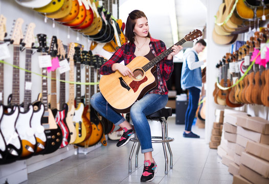 Teenager choosing acoustic guitars
