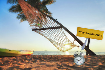 Work life balance concept and time management idea.Work life balance word on wooden sign and time management word on alarm clock on tropical beach background