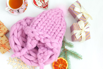 Handmade knitwear composition with warm hat of pastel color