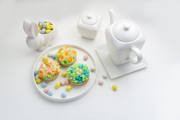 Easter theme decorated cupcakes on white Background with a bunny.