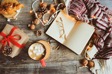weekly planner or to do list top view with Christmas decorations and hot cocoa. Choosing gifts and...