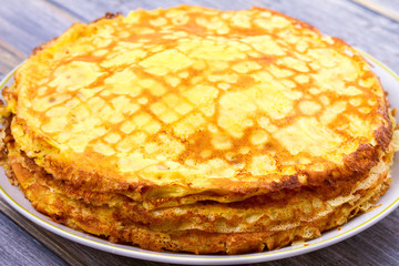 Stack of thin pancakes, crepes on white plate, horizontal