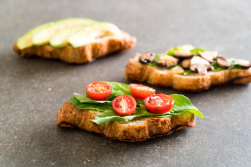 croissant sandwich with avocado, tomatoes and mushroom