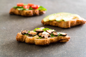 croissant sandwich with avocado, tomatoes and mushroom