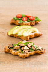 croissant sandwich with avocado, tomatoes and mushroom