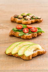 croissant sandwich with avocado, tomatoes and mushroom