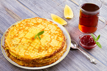 Stack of thin pancakes, crepes on white plate, horizontal