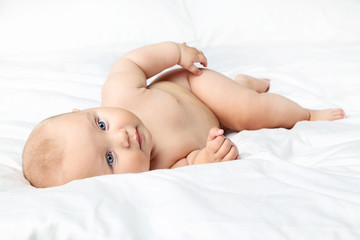 Little newborn baby on white bed