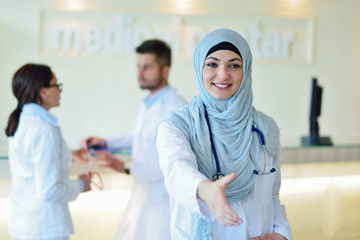 Obraz premium Young happy smiling female muslim doctor giving hand for handshaking