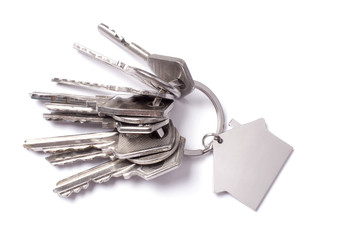 Keys and keychain in the shape of a house isolated on white background.
