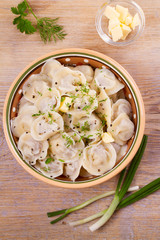 Dumplings, filled with meat, ravioli. Traditional Russian dish pelmeni. Dumplings with filling. View from above, top studio shot, vertical