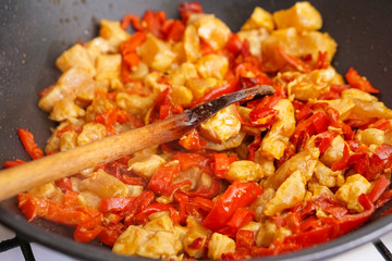 Preparation of cutted paprika with chicken meat in black frying pan