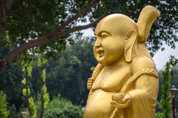 Golden laughing Buddha sculpture at a Buddhist monastery at Sarnath, Varanasi