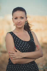Fototapeta premium Hot sexy stylish dressed young lady brunette hairs and pinky cheeks with open legs shoulders and arms posing sensuality on sea side rocky beach. seductive woman awaiting her future seaman husband