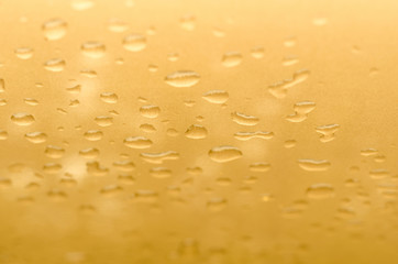 texture of a drop of water on a yellow glossy surface
