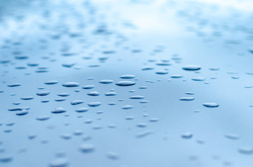 texture of a drop of water on a blue glossy surface