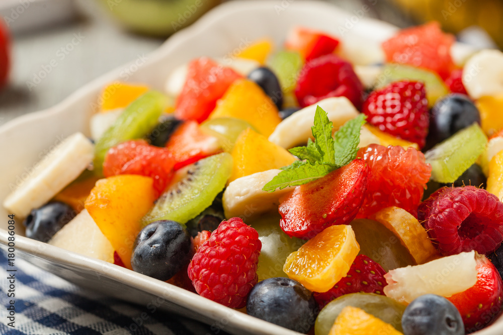 Wall mural delicious fruit salad with fresh fruit. wooden, gray table in the background.