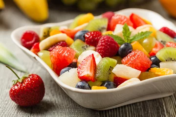 Crédence de cuisine en verre imprimé Fruits Délicieuse salade de fruits aux fruits frais. Table grise en bois en arrière-plan.
