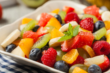 Delicious fruit salad with fresh fruit. Wooden, gray table in the background.