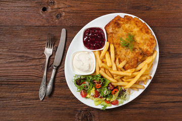Chicken schnitzel, served with fries and salad.