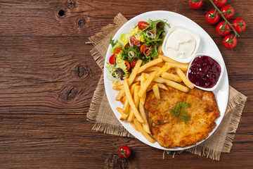 Chicken schnitzel, served with fries and salad.