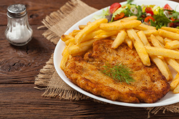 Chicken schnitzel, served with fries and salad.